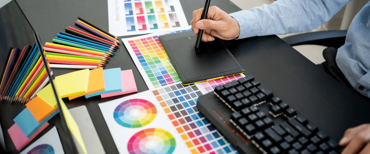 Antony, a web and print designer, seated at his computer, meticulously creating a vibrant color template for print materials like leaflets and business cards